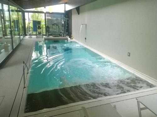 a swimming pool in a building with a water feature at Petit Relais Chateau nel verde in Borgo San Dalmazzo