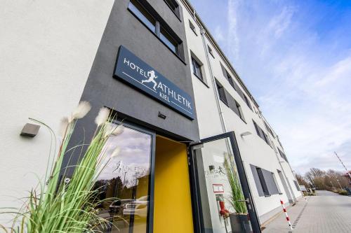 a building with a sign on the side of it at Hotel Athletik Kiel in Altenholz
