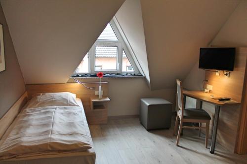 1 dormitorio con cama, escritorio y ventana en Hotel Gasthof Grüner Wald en Hofheim am Taunus