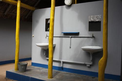 baño con 2 aseos y lavamanos en una habitación en Complexo Alemanha - Vilanculos Backpacker, en Vilanculos