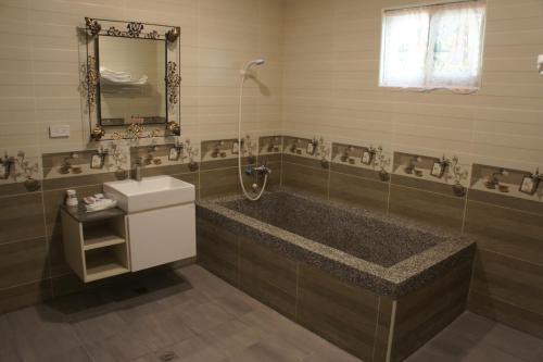a bathroom with a tub and a sink and a mirror at Paris Motel in Mailiao