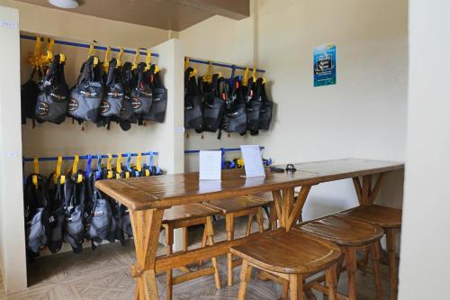 a room with a wooden table and some baseball bats at Turtle Bay Dive Resort in Moalboal