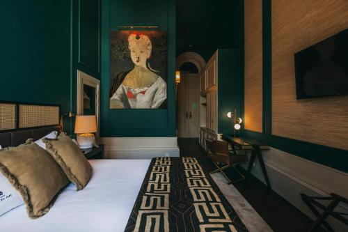 a bedroom with a bed with a painting on the wall at Torel 1884 Suites & Apartments in Porto
