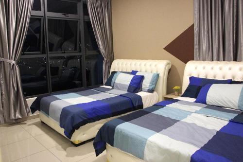 a bedroom with two beds and a window at ATLANTIS@MELAKA BY SWEETSTAY in Melaka
