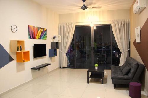 a living room with a couch and a chair and a television at ATLANTIS@MELAKA BY SWEETSTAY in Melaka