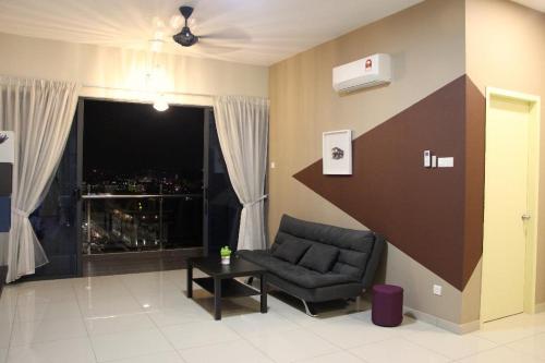 a living room with a chair and a large window at ATLANTIS@MELAKA BY SWEETSTAY in Melaka