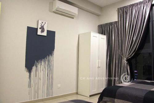 a bedroom with a bed and a wall with a clock at ATLANTIS@MELAKA BY SWEETSTAY in Melaka