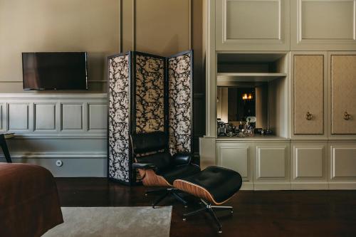 a living room with a chair and a television at Torel 1884 Suites & Apartments in Porto
