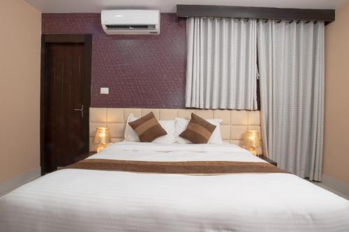 a bedroom with a large white bed and a window at Annapurna Hotel in Bīrganj