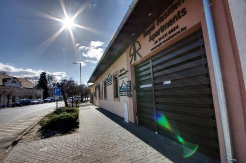 a building with a garage door on the side of a street at Royal Residence Apartments in Gyula