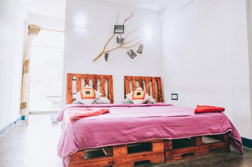um quarto com uma cama grande e um cobertor rosa em Hugging Clouds em Nallathanniya