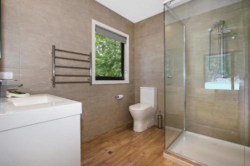 a bathroom with a toilet and a glass shower at Telluride in Harrietville