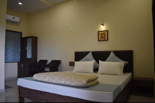 a bedroom with a large bed with white pillows at Windchime Cottages in Alibaug