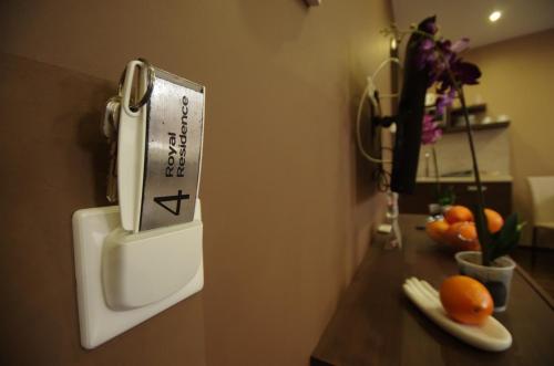 a thermometer on a wall next to a table with oranges at Royal Residence Apartments in Gyula