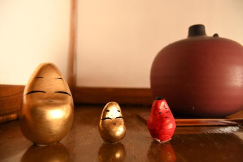 a group of three small figurines on a table at Tsubaki - the best guesthouse in Inawashiro - in Inawashiro