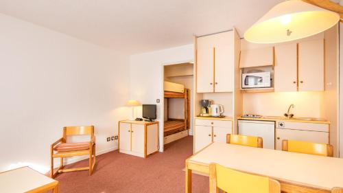 une cuisine et une salle à manger avec une table et des chaises dans l'établissement Vacancéole - Résidence La Croix Margot, à Villard-de-Lans