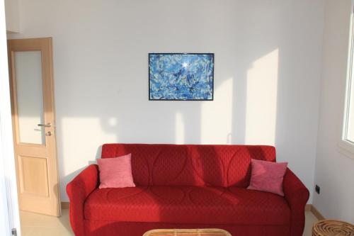 a red couch with two pink pillows in a room at B&B Lil in Brenzone sul Garda