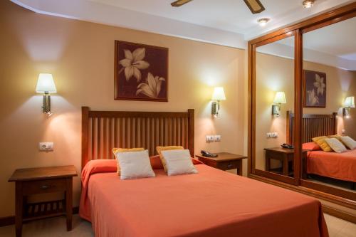 ein Hotelzimmer mit 2 Betten und einem Spiegel in der Unterkunft Aparthotel El Galeón in Santa Cruz de la Palma