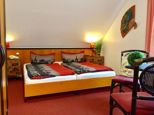 a bedroom with a bed and a chair at Pension Cora in Boltenhagen