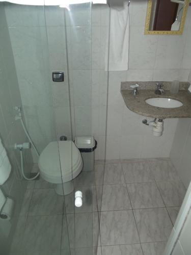 a bathroom with a shower and a toilet and a sink at Pousada Flats Paguru in Búzios