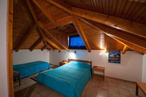 a bedroom with two beds and wooden ceilings at Athina Hotel in Kréstena