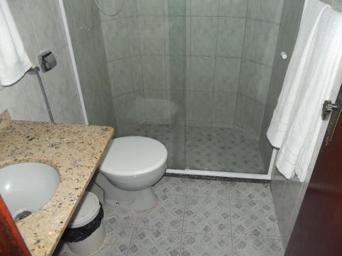 a bathroom with a toilet and a sink and a shower at Pousada Flats Paguru in Búzios