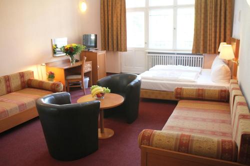 a hotel room with a bed and a table and chairs at Hotel Aster an der Messe in Berlin
