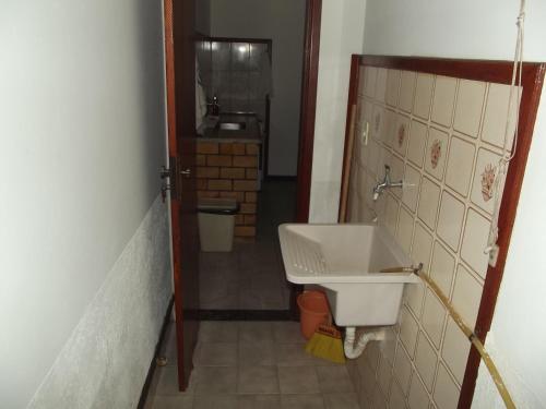 a small bathroom with a sink and a mirror at Pousada Flats Paguru in Búzios