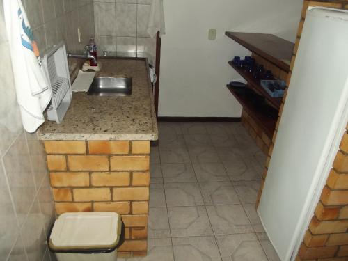 a small kitchen with a sink and a counter at Pousada Flats Paguru in Búzios
