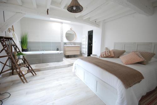 a bedroom with a large bed and a bath tub at Le Romarande, Cottage détente avec SPA privatif in Heubécourt