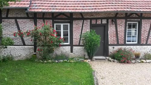 uma casa de tijolos com uma porta e uma janela em Le Romarande, Cottage détente avec SPA privatif em Heubécourt