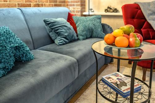 a living room with a couch and a table with fruit on it at Arkadia Plaza Design Apartment in Odesa