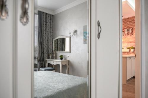 a bedroom with a bed and a mirror at Arkadia Plaza Design Apartment in Odesa
