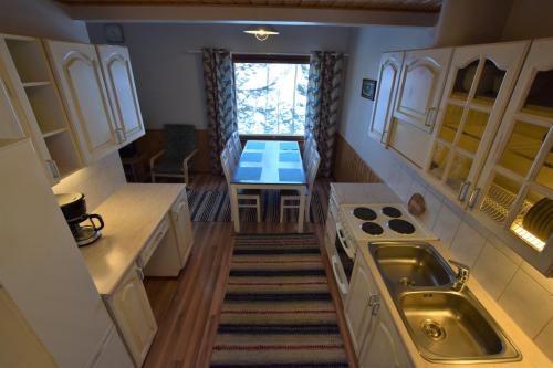 a small kitchen with a sink and a table at Pyhtään Vuokramökit in Tuuski
