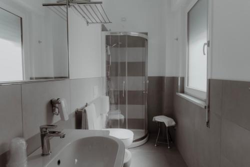 a bathroom with a sink and a toilet and a mirror at Hotel Caravel in Vasto