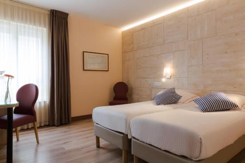 um quarto de hotel com duas camas e uma janela em The Originals Boutique, Hôtel Alizé, Évian-les-Bains (Inter-Hotel) em Évian-les-Bains