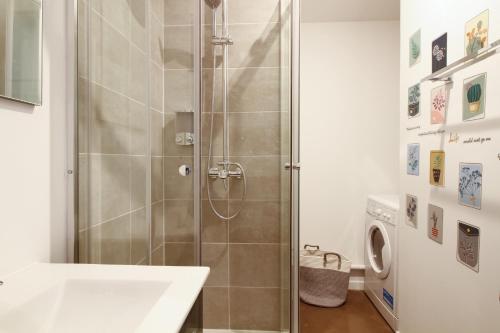 una doccia con una porta in vetro in un bagno di STUDIO LE CHOUETTE a Digione