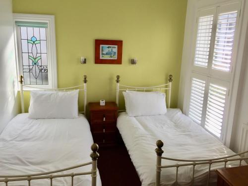 a bedroom with two beds and a window at Derrin Guest House in Larne