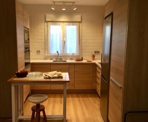 a kitchen with a table and a refrigerator at El Corral De La Simona in Villalmanzo