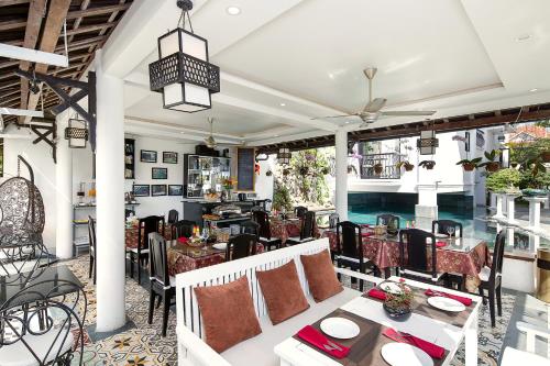 patio ze stołami i krzesłami oraz restaurację w obiekcie Riverside Impression Villa w Hoi An