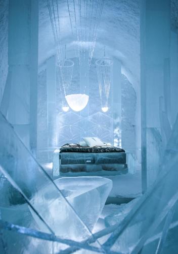 a room with a bed and a table with lights at IceHotel in Jukkasjärvi