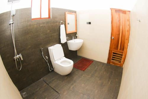a bathroom with a toilet and a sink at Bay Hiriketiya in Hiriketiya