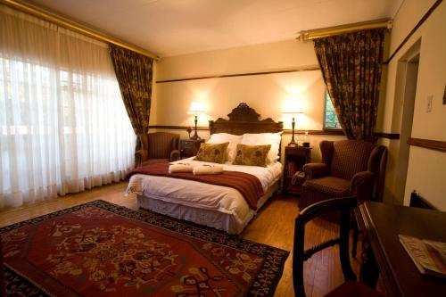 um quarto de hotel com uma cama e uma cadeira em Brooklyn Place em Pretoria