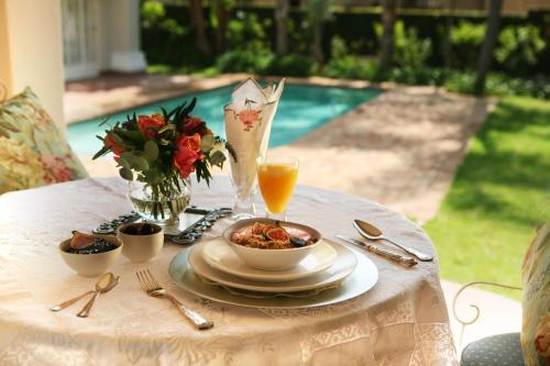stół z miską jedzenia i szklanką soku pomarańczowego w obiekcie Brooklyn Place w mieście Pretoria