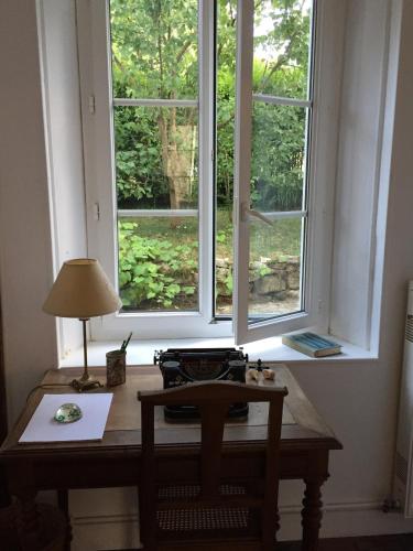 - un bureau avec une lampe devant une fenêtre dans l'établissement Chez Fred et Cécile, à Verdilly
