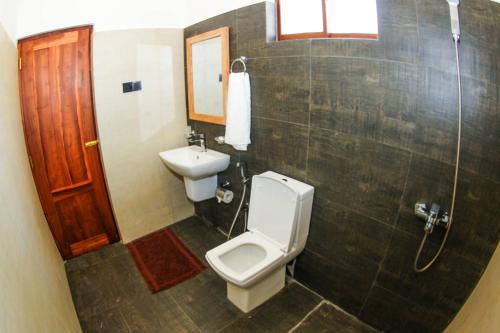 a bathroom with a toilet and a sink at Bay Hiriketiya in Hiriketiya