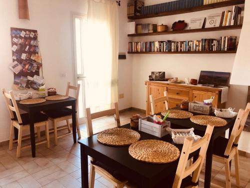 a room with two tables and chairs and a kitchen at B&B La Pintadera in Santa Teresa Gallura