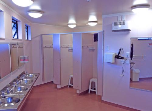 a bathroom with four sinks and a row of stalls at Picton Campervan Park in Picton