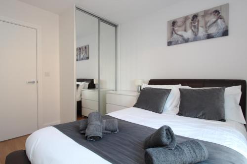 a bedroom with a large bed with towels on it at Luxury Apartments With Secure Parking in Reading