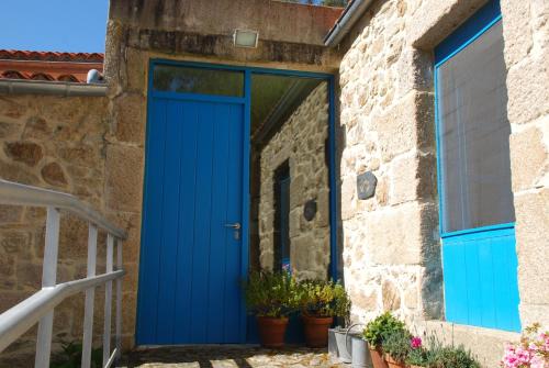 a blue door on a stone building with potted plants at Budiño de Serraseca in Oia